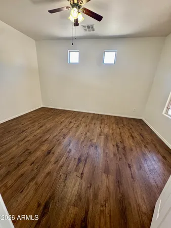 a view of a big room with wooden floor and a ceiling fan
