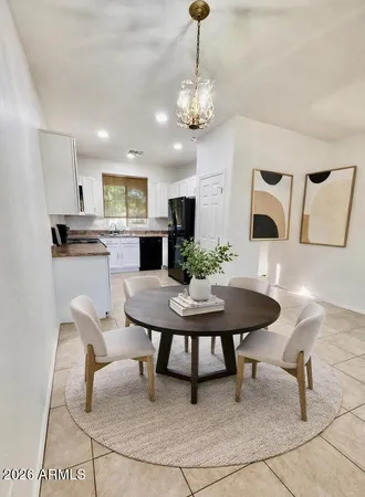 a view of a dining room and kitchen with furniture a rug and wooden floor