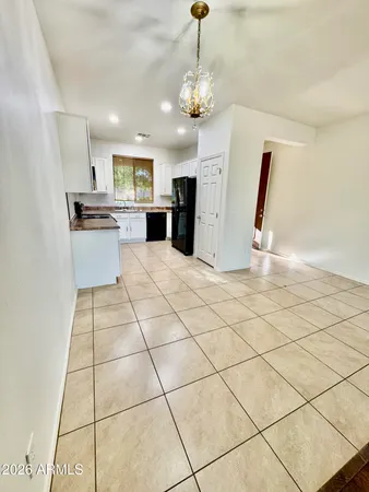 a view of a kitchen with kitchen island white cabinets and stainless steel appliances