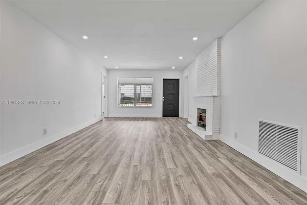 a kitchen with cabinets stainless steel appliances and wooden floor