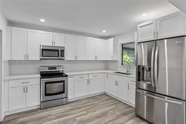 a kitchen with white cabinets and stainless steel appliances