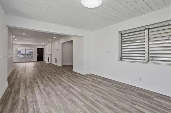 an empty room with wooden floor and a window