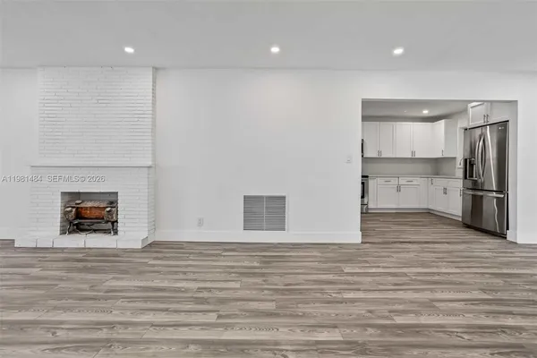 a view of a livingroom with wooden floor and a fireplace