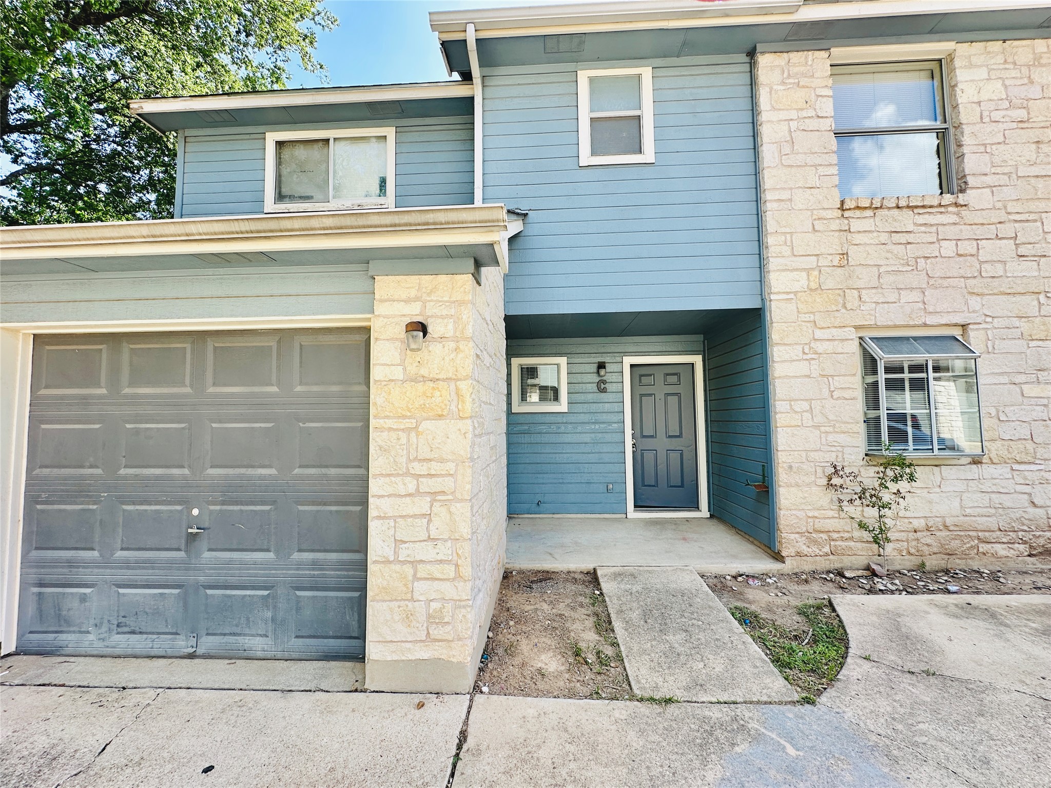 8814 Schick Road, Unit C Austin, TX 78729 - Photo 2 of 35 A welcoming stone and siding facade with an attached garage offers appealing curb appeal.
