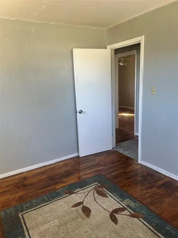 an empty room with wooden floor and closet
