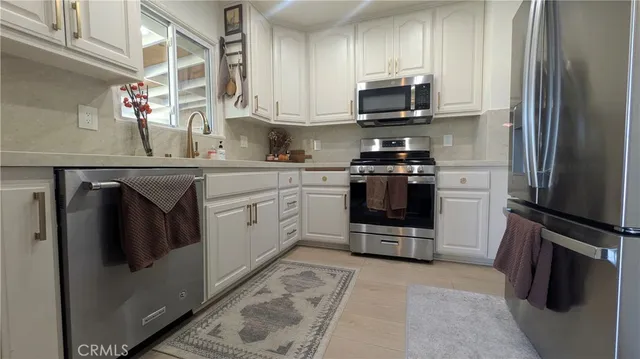 a kitchen with stainless steel appliances granite countertop a stove a refrigerator and a microwave