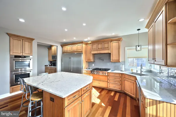 a kitchen with stainless steel appliances granite countertop a refrigerator a microwave and oven