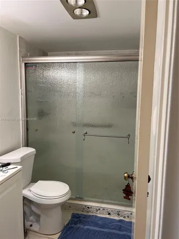 a bathroom with a toilet and a shower
