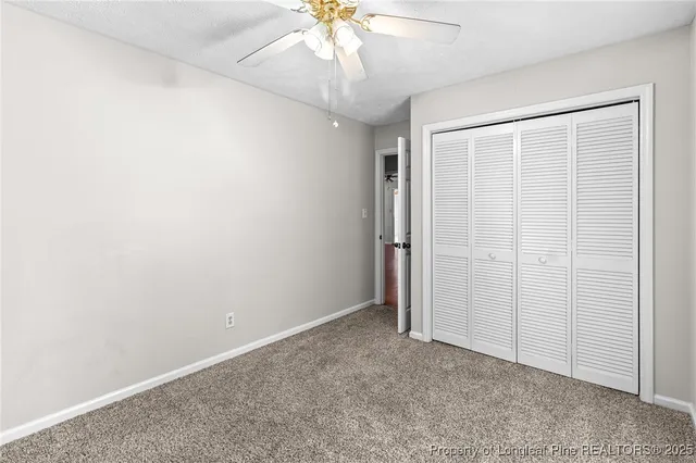 an empty room with a ceiling fan and a window