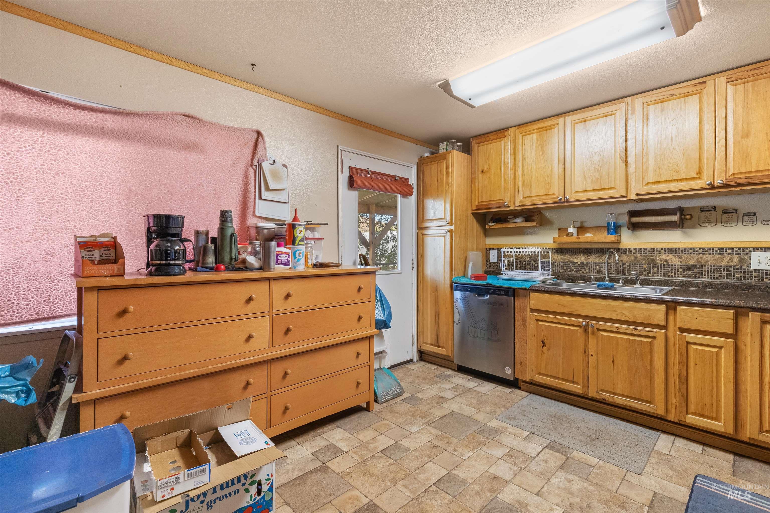 2460 State Street Pomeroy, WA 99347 - Photo 4 of 18 Kitchen featuring natural wood cabinetry, stainless steel dishwasher, tile flooring, and a patterned tile backsplash