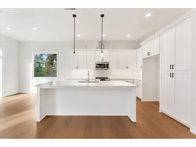 a large white kitchen with a white sink