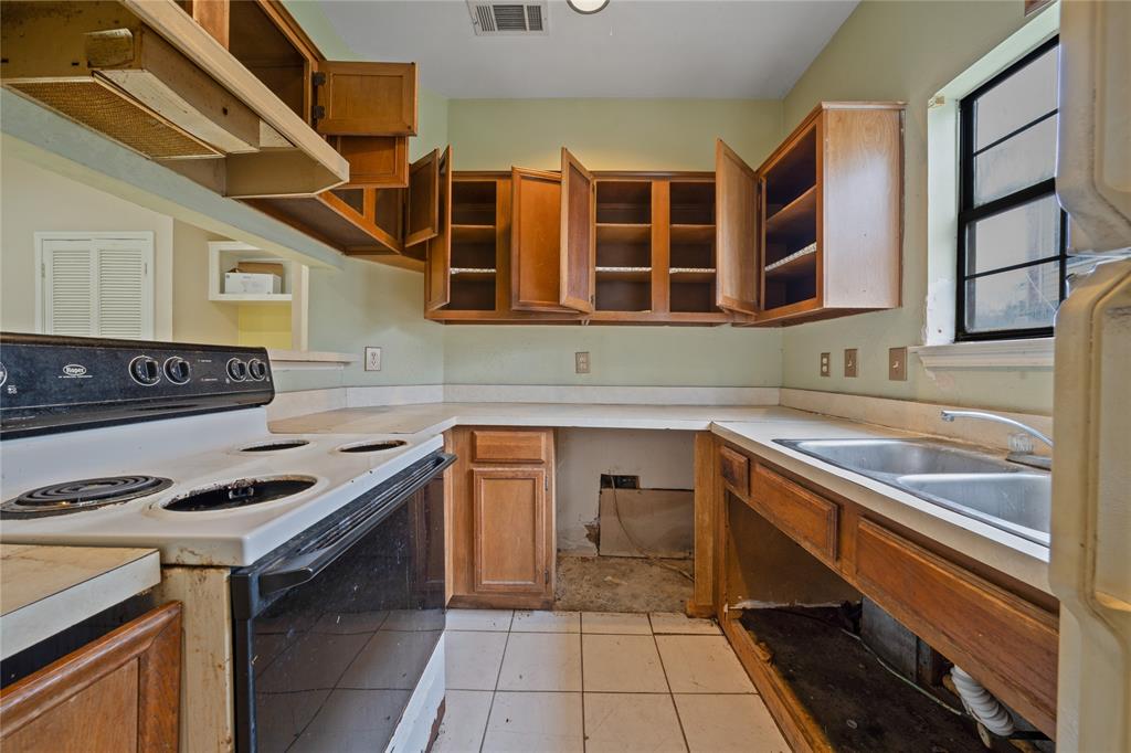 4434 Point Boulevard, Unit 108 Garland, TX 75043 - Photo 5 of 13 a kitchen with stainless steel appliances granite countertop a stove and a sink