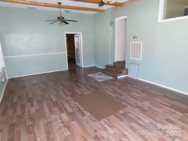 a view of a livingroom with wooden floor and a ceiling fan