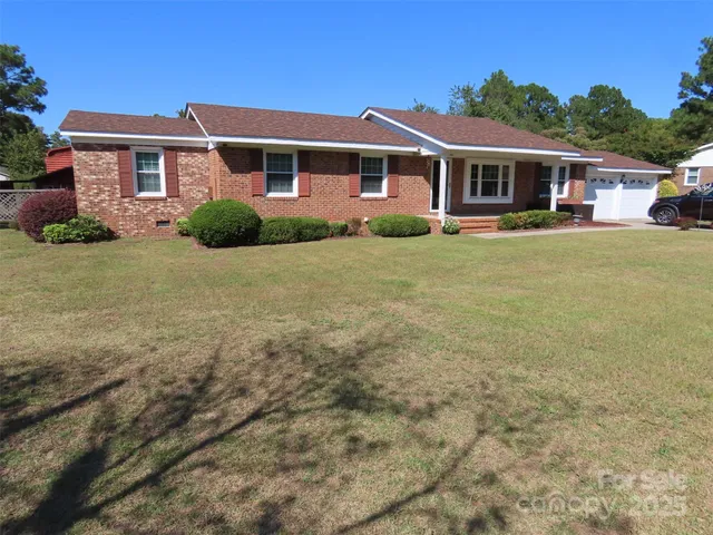 a front view of a house with a yard and trees