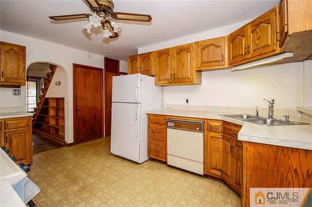 219 Lambertson Road Old Bridge, NJ 07747 - Photo 7 of 21 a kitchen with stainless steel appliances granite countertop a refrigerator a sink dishwasher a stove with wooden cabinets and floor