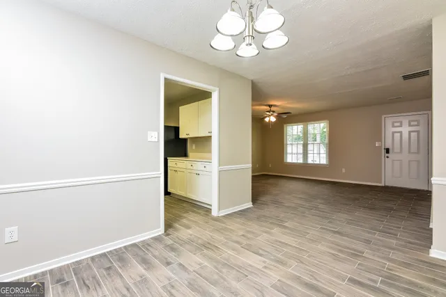 a view of a kitchen with wooden floor and cabinets