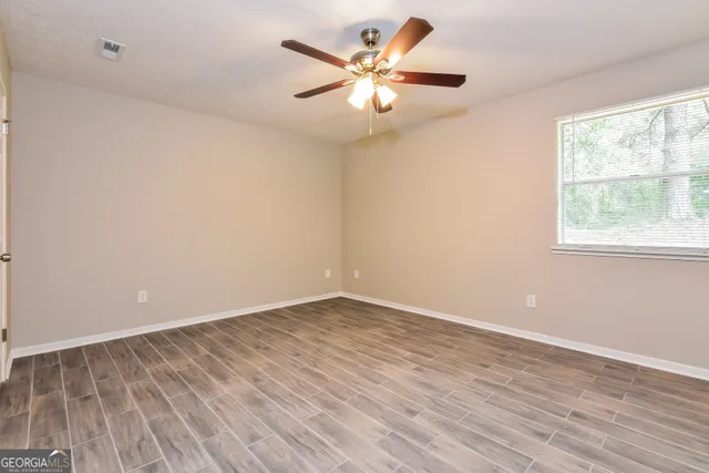wooden floor in an empty room with a window