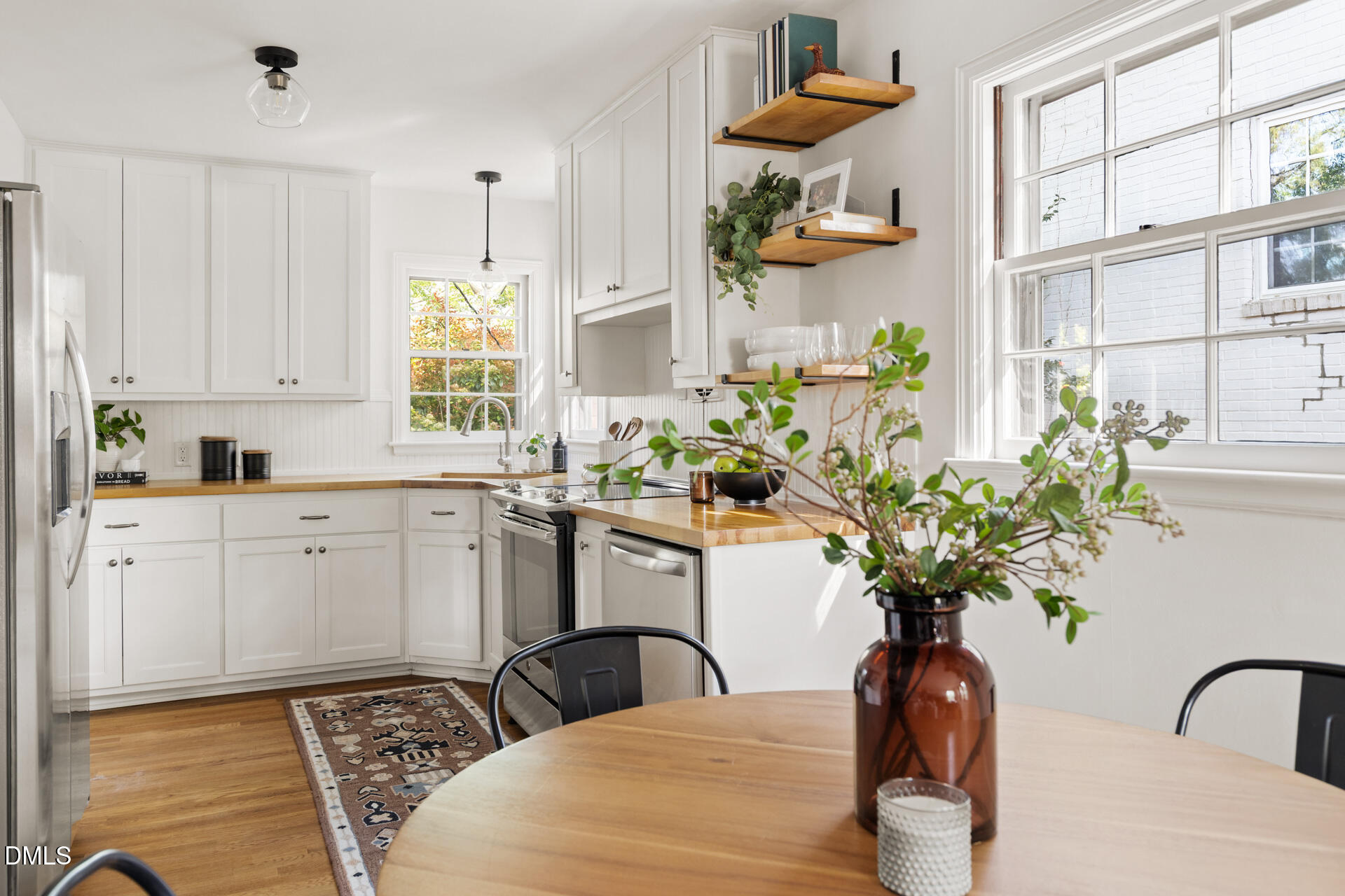 1414 Acadia Street Durham, NC 27701 - Photo 13 of 46 a kitchen with stainless steel appliances a white table a potted plant and a window