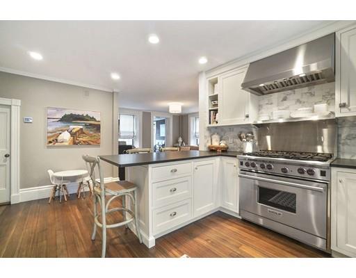 27 Pearl Street Marblehead, MA 01945 - Photo 2 of 25 a kitchen with stainless steel appliances a stove a sink dishwasher and white cabinets with wooden floor