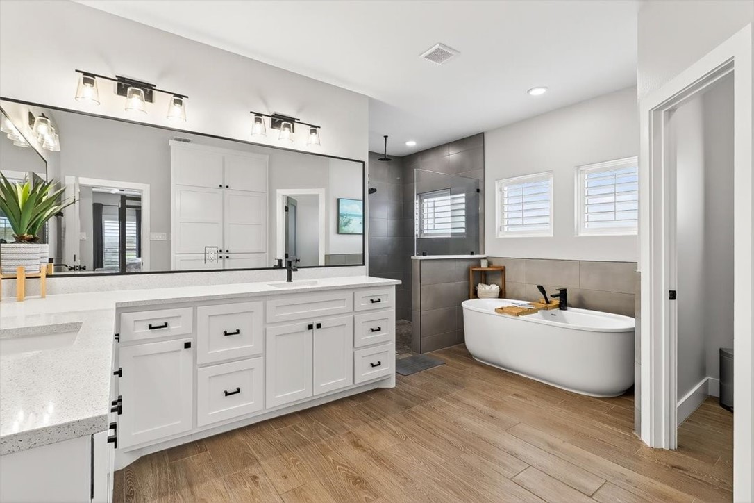 8738 KIng Ranch Drive Corpus Christi, TX 78414 - Photo 7 of 40 a spacious bathroom with double vanity sink a two mirror a window a bathtub and vanity