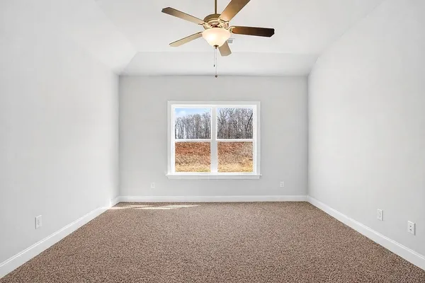 an empty room with a window and a fan