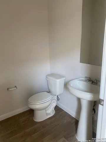 a white toilet sitting next to a bathroom sink and vanity