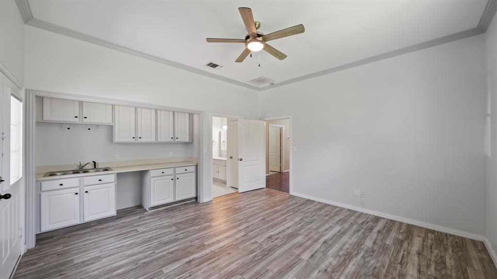 875 Arnold Paul Road Canton, TX 75103 - Photo 22 of 32 a large white kitchen with wooden floor and a ceiling fan