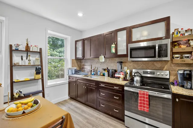 a kitchen with stainless steel appliances a stove sink microwave and cabinets