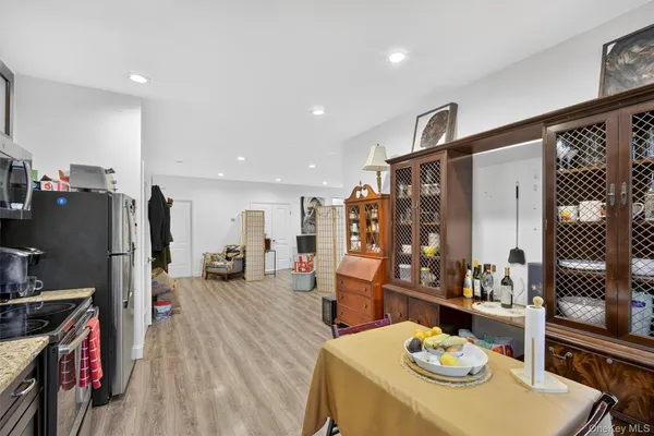 a living room with stainless steel appliances furniture a table and chairs