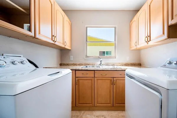 a utility room with sink dryer and washer