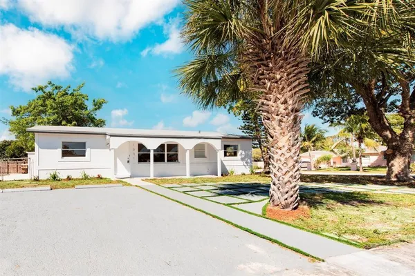 a front view of house with yard and trees around