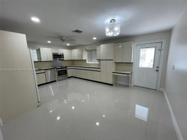 a large kitchen with kitchen island a sink stainless steel appliances and cabinets