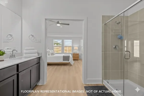 a living room with furniture a kitchen view and a wooden floor