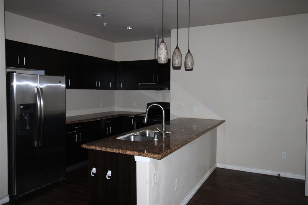 1100 West Trinity Mills Road, Unit 3035 Carrollton, TX 75006 - Photo 8 of 12 a kitchen with a sink and refrigerator