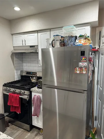 a view of a kitchen area with furniture and wooden floor