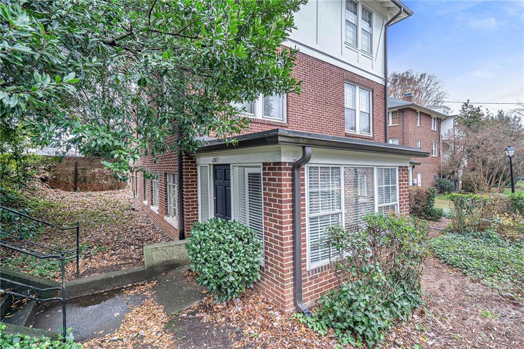 230 Providence Road Charlotte, NC 28207 - Photo 25 of 29 a view of a house with brick walls and a flower garden
