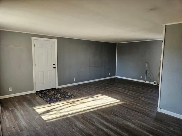 a view of a room with wooden floor and white walls
