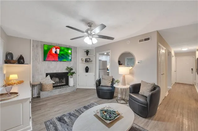 a living room with furniture a fireplace and a flat screen tv