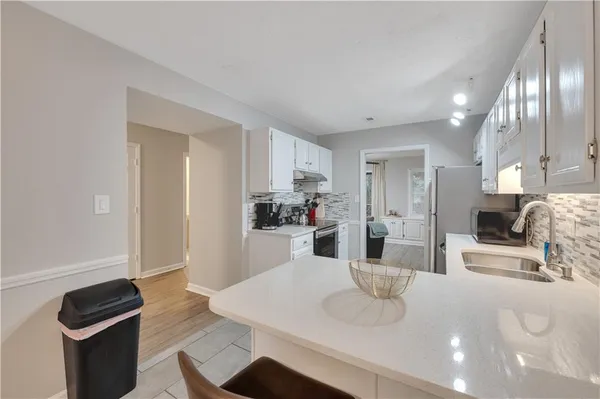 a kitchen with stainless steel appliances granite countertop a sink refrigerator and cabinets