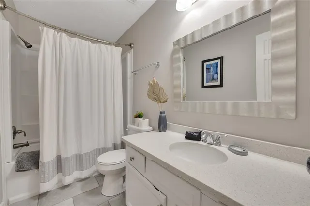 a bathroom with a toilet sink a mirror and shower curtain