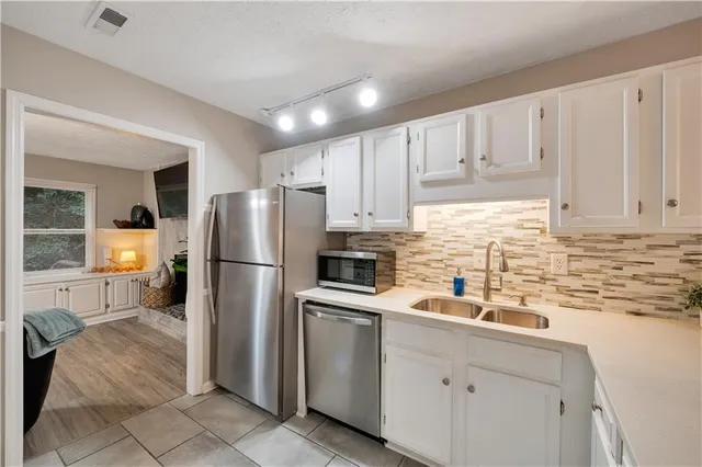 a kitchen with a sink stainless steel appliances and white cabinets