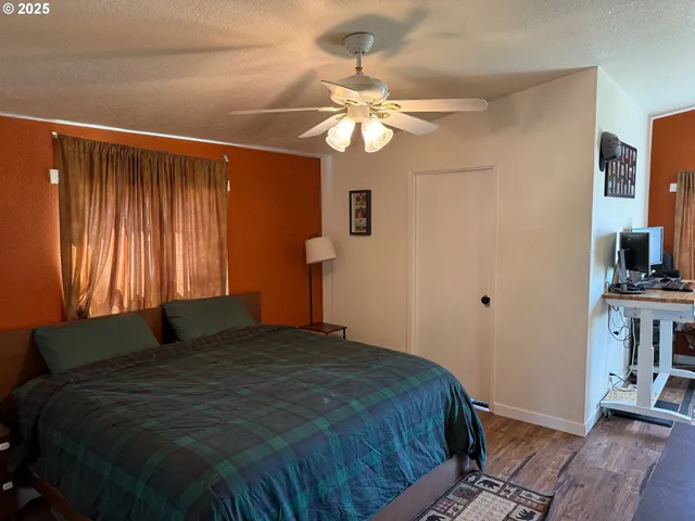 a bedroom with a bed cabinets and a window