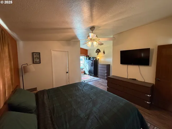 a living room with a bed furniture and a flat screen tv