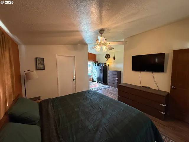 a living room with a bed furniture and a flat screen tv