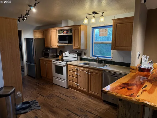 a kitchen with stainless steel appliances granite countertop a sink stove and refrigerator