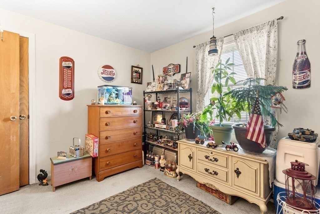 18 Woodman Way, Unit 17 Newburyport, MA 01950 - Photo 11 of 24 a room with a baby crib a chandelier and a couch