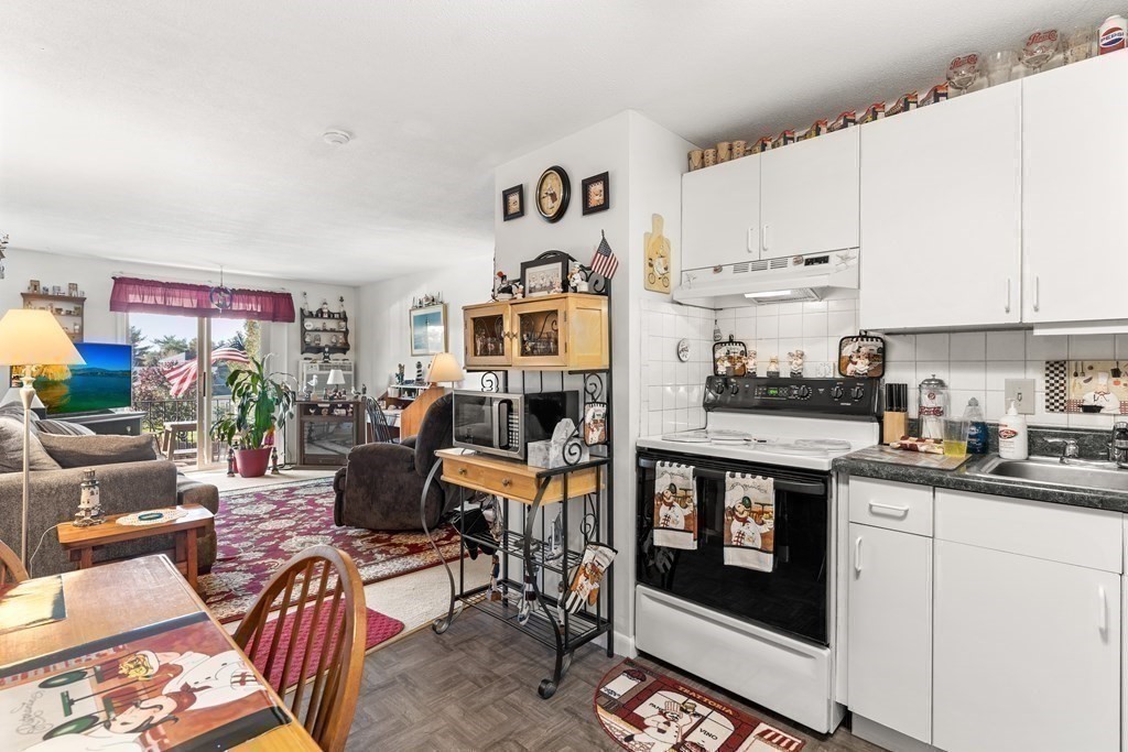 18 Woodman Way, Unit 17 Newburyport, MA 01950 - Photo 12 of 24 a kitchen with stainless steel appliances granite countertop a stove and a refrigerator