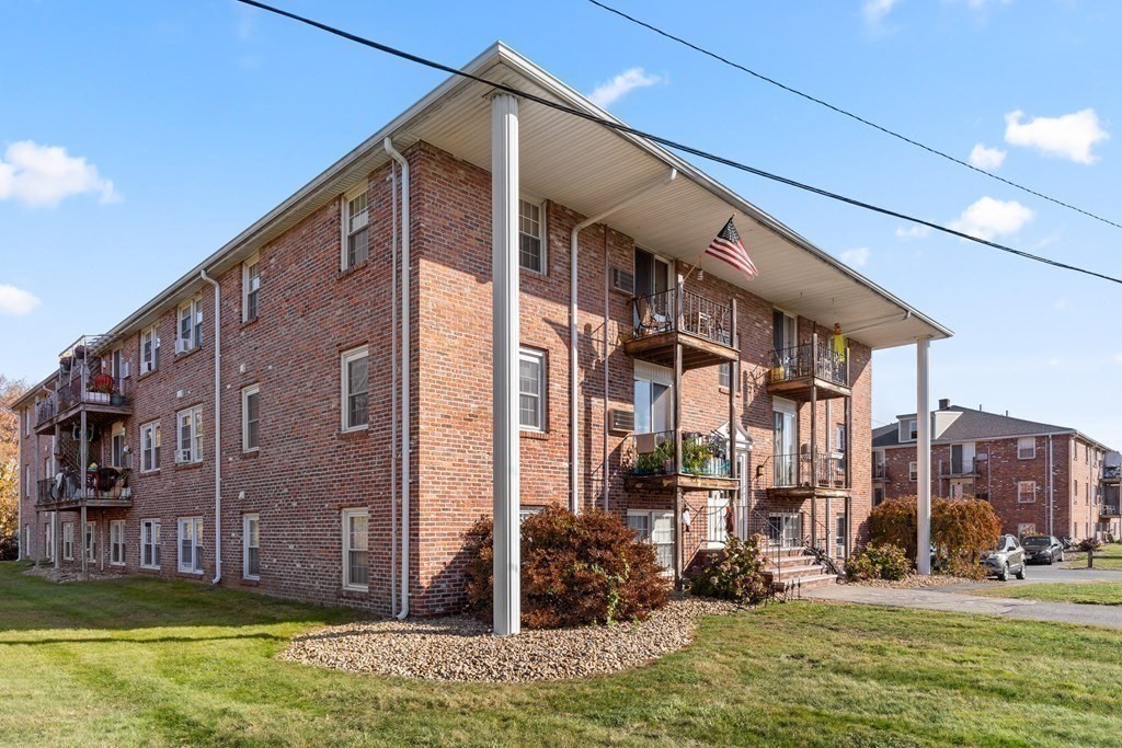 18 Woodman Way, Unit 17 Newburyport, MA 01950 - Photo 18 of 24 a view of a building with a yard