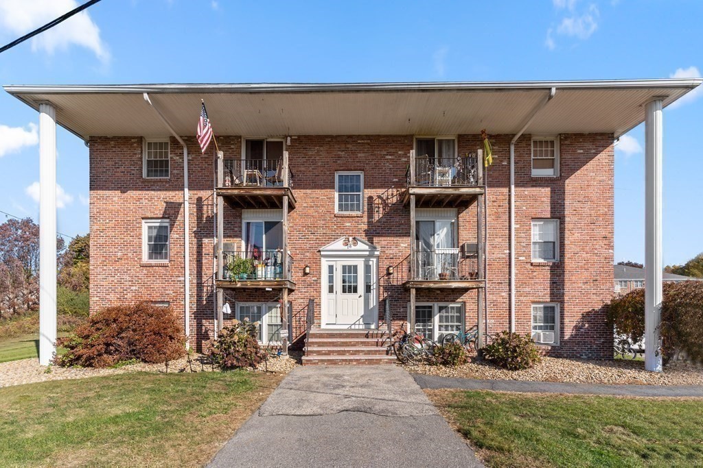 18 Woodman Way, Unit 17 Newburyport, MA 01950 - Photo 19 of 24 a front view of a building with a garden