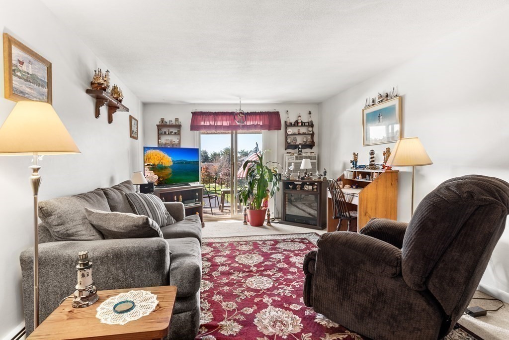 18 Woodman Way, Unit 17 Newburyport, MA 01950 - Photo 4 of 24 a living room with furniture and a lamp